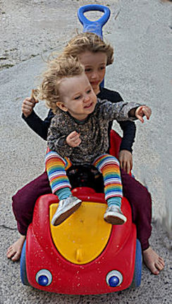 Kairos and Dino on the red push car